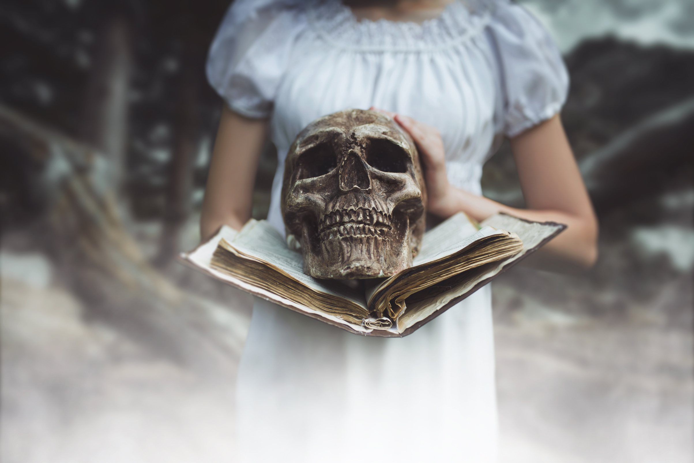 Female Victim Holds Book and Human Skull in Hand